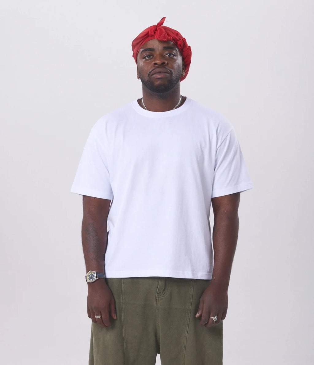 A man wearing a white hemp tee on a white background